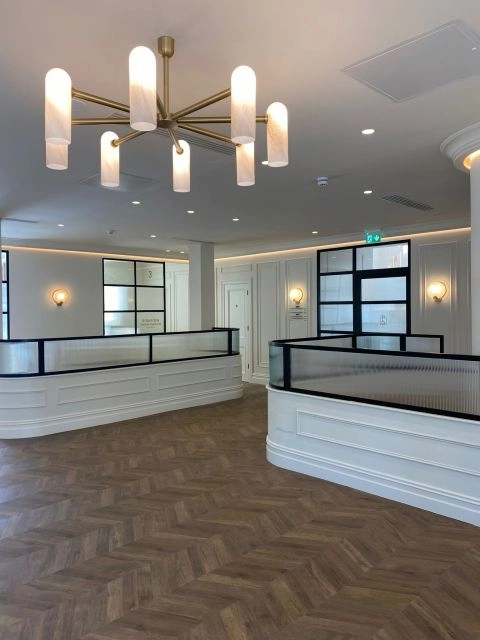 Curved steel glazed screens with reeded glass above the reception desks at College Road Medical Centre, Cork, by IDS